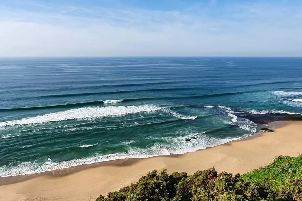 The remote beach of Praia da Vigia with an a-frame wave