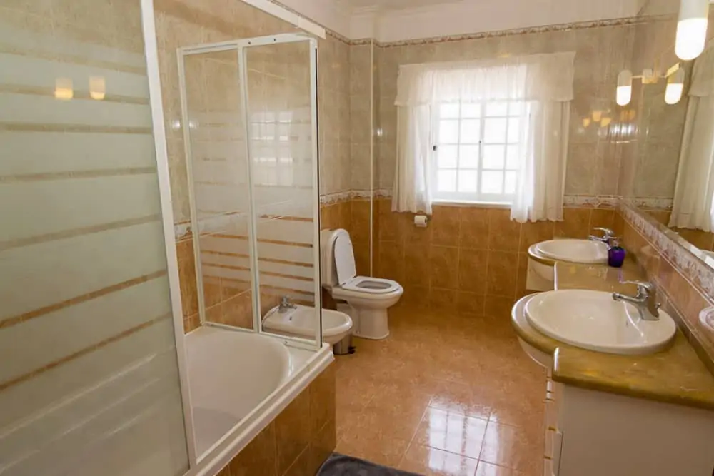 Shared bathroom with shower, double washbasin, toilet and bidet