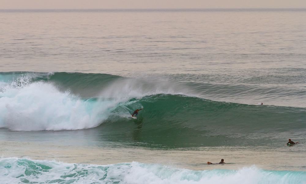 Surfing a perfect lefthand barrel at the surf spot Foz do Lizandro